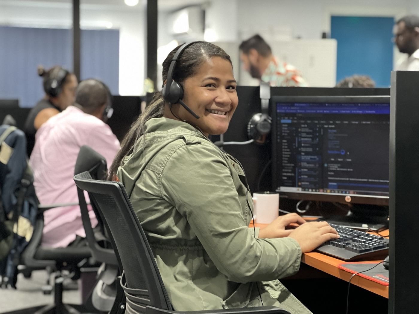 A NexOutsource customer support agent at her workstation in Suva